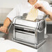 A person using an Imperia pasta machine to make dough.