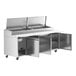 An Avantco stainless steel refrigerated pizza prep table with open doors.