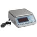 A grey Edlund BRAVO! digital portion scale on a counter with a black cord and clear screen.