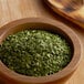 A bowl of Regal Cilantro leaves on a wooden table.