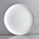 A white Arcoroc round opal glass pizza plate.