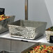 A group of American Metalcraft hammered stainless steel square bowls with food in them.