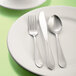 A white plate with a Libbey stainless steel medium weight salad fork on it.