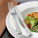 A plate of salad with a Libbey stainless steel dinner knife and fork.