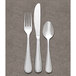 A Libbey stainless steel dinner fork on a gray surface.