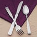 A Libbey Salem stainless steel knife and fork on a purple napkin.
