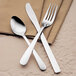 A Libbey Windsor stainless steel dessert spoon and a fork on a napkin.