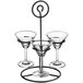 An Acopa metal stand holding three martini glasses.