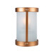 A Sterno copper and glass votive candle holder on a wall above a lit candle.