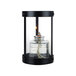 A Sterno black glass votive candle holder with a flame inside.