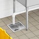 A Regency stainless steel floor sink with a drain in a kitchen.
