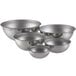 A set of five silver stainless steel Vollrath mixing bowls on a white background.