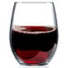 An Arcoroc Perfection stemless wine glass filled with red wine on a table.