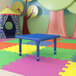 A blue Flash Furniture square activity table in a playroom.