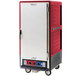 A red and grey rectangular Metro C5 heated holding and proofing cabinet with wheels.