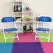 Two blue Flash Furniture kids plastic folding chairs on a colorful mat.