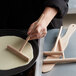 A person using Fox Run beechwood crepe batter spatula and spreaders to make crepes.