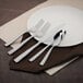 A white plate with a Walco stainless steel European dinner fork on it.