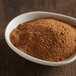 A bowl of McCormick Pumpkin Pie Spice powder on a wooden table.