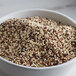 A bowl of Bob's Red Mill Organic Tri-Color Quinoa seeds.