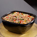 A black Sabert catering bowl filled with rice and vegetables on a table.