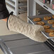 A person using 17" terry oven mitts to take a tray of cookies out of the oven.