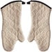 A pair of beige terry oven mitts with black steam barriers.