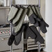 A rack with SafeMitt flame retardant oven mitts hanging from it.