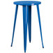 A blue round table with legs with two blue metal stools.