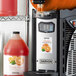 A machine with a container of Narvon Orange Slushy Concentrate next to it.