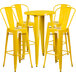 A Flash Furniture yellow metal bar height table with four yellow metal chairs around it.