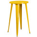 A yellow metal Flash Furniture bar table with yellow metal legs and a yellow surface with 4 yellow metal stools with wooden seats.