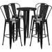 A Flash Furniture black metal bar height table with black chairs around it.