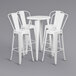 A Flash Furniture white metal bar height table with white metal chairs.