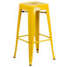 A yellow metal table with two square stools with yellow seats.