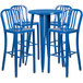 A blue metal round bar table with four blue stools with vertical slat backs.