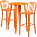 An orange round bar height table with two orange chairs with vertical slat backs.