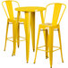 A Flash Furniture yellow metal bar height table with two yellow metal chairs.