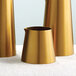 Three American Metalcraft gold satin stainless steel creamers on a table.