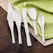 A Walco stainless steel salad fork on a white plate with a green napkin.