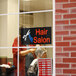 A rectangular LED salon sign with a woman cutting hair.
