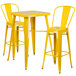 A yellow metal bar table with two yellow bar stools.