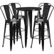 A Flash Furniture black metal bar table with four black metal chairs.