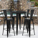 A Flash Furniture black metal bar height table with 4 black bar stools.