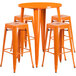 An orange metal round bar table surrounded by four square orange backless stools.