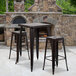 A Flash Furniture bar height table and two backless stools in front of a brick fireplace.