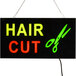 A white rectangular LED sign with "hair cut" in red and green letters.