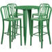 A green metal bar height table with four green chairs.