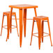 An orange metal Flash Furniture bar table with two square stools.