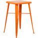 An orange metal Flash Furniture bar height table with legs.